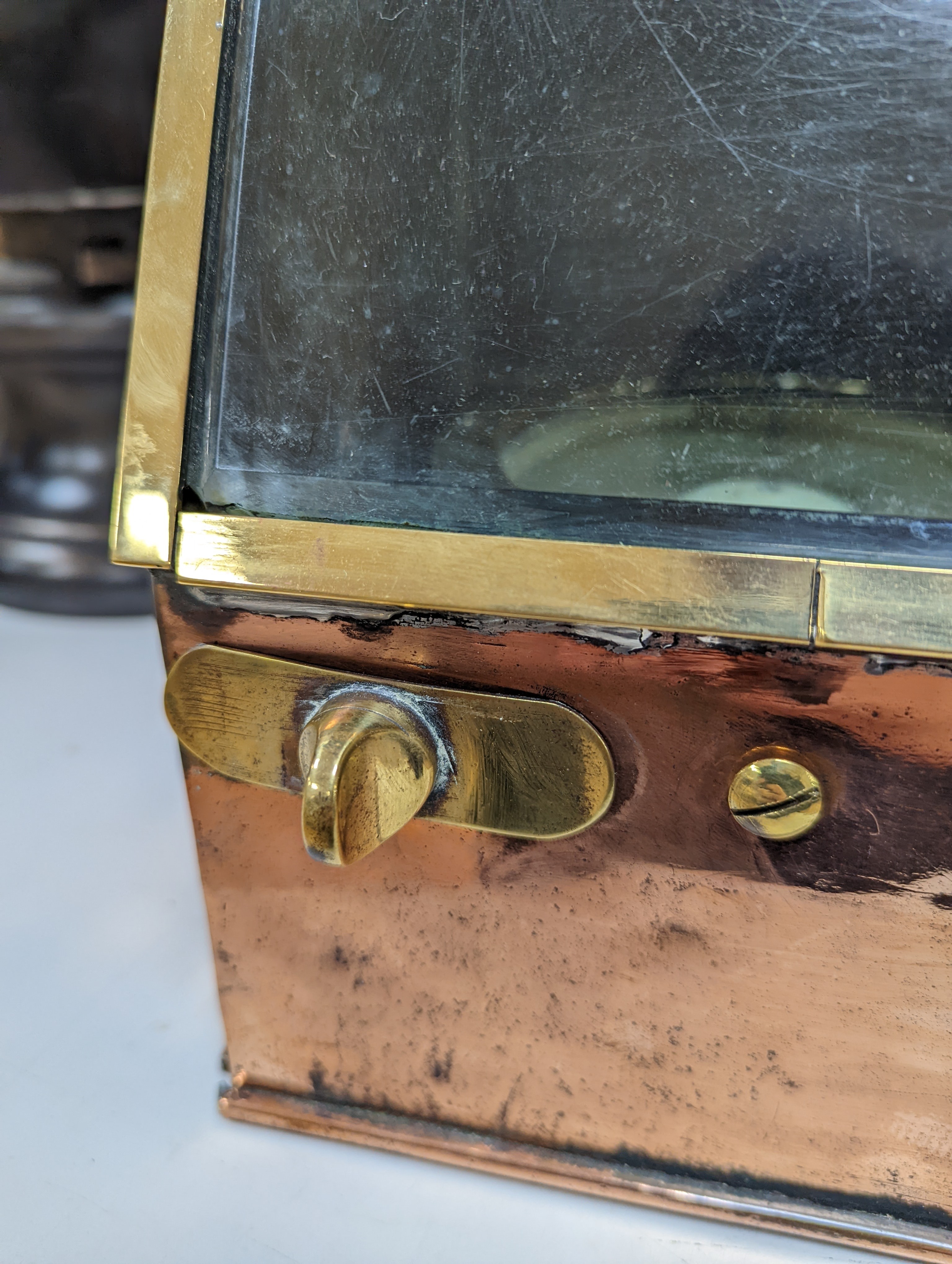 A copper ship's binnacle compass, a brass oil lamp, a brass jug and a copper kettle